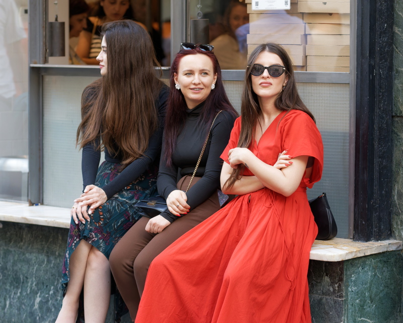 18 - Three women dressed in a red maxi dress, a long-sleeved black top, and a floral print skirt